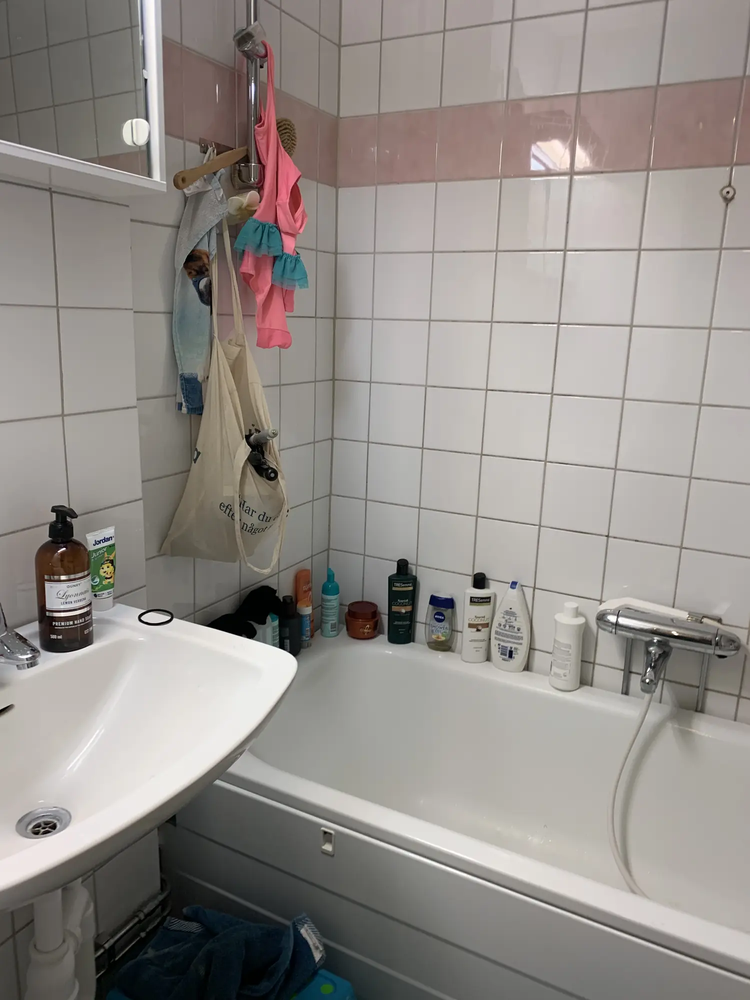 Badrum med kakel och badkar före renovering