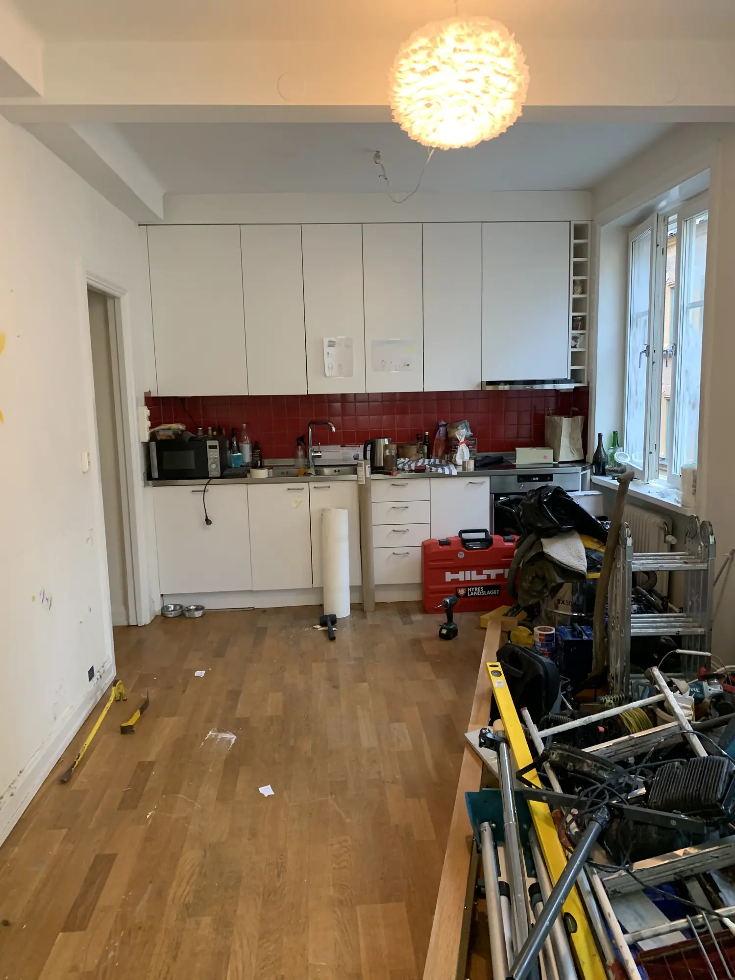 Rum under rivning med röda skåp före renovering