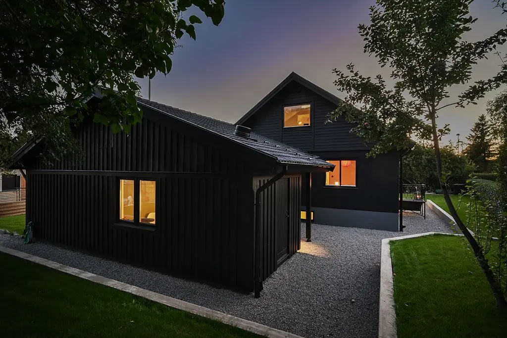 Mörkt hus i skymning med upplysta fönster
